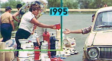 Жінка продає каструлі і чайники при дорозі біля Новомосковського заводу в Дніпропетровській області. Наразі робітники українських заводів через економічну кризу в країні в якості заробітної плати отримують продукцію фабричного виробництва. /Getty Images