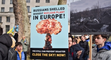 ЛОНДОН, ВЕЛИКАЯ БРИТАНИЯ, 13 марта 2022 года: протестующий держит плакат с предупреждением о ядерной угрозе России. Тысячи людей собрались возле Даунинг-стрит в поддержку Украины /Getty Images
