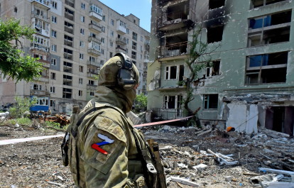 Російський військовий на тлі зруйнованого будинку в Сєвєродонецьку, Україна, 12 липня 2022 р. /Фото Getty Images