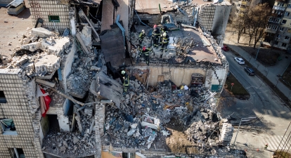 Вид сверху: пожарные работают на развалинах жилого дома, в который попали обломки сбитой ракеты, Киев, 17 марта 2022 года. /Getty Images