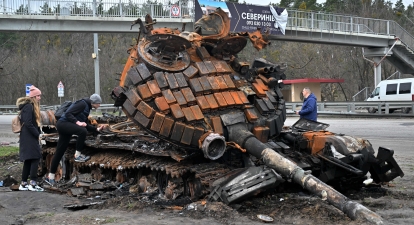 Жителі дивляться на знищений російський танк на околиці села Бузова, на захід від Києва, 10 квітня 2020 року /Getty Images