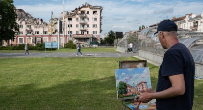 Чоловік малює зруйнований чернігівський будинок, кінець травня 2022 року /Getty Images