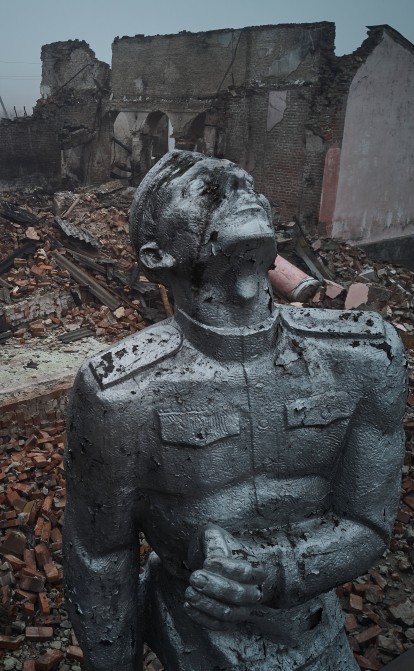Статуя радянського солдата на тлі зруйнованого ракетним обстрілом будинку культури на околиці міста Авдіївка 26 жовтня 2023 року. /Getty Images