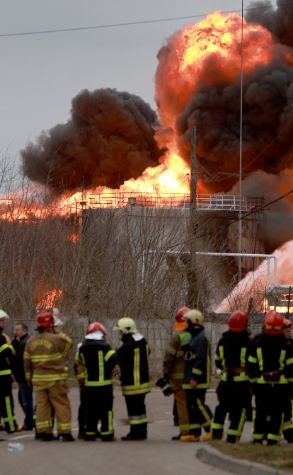 Пожарные пытаются потушить огонь после того, как российские управляемые ракеты поразили нефтебазу во Львове 27 марта 2022 года. /Getty Images