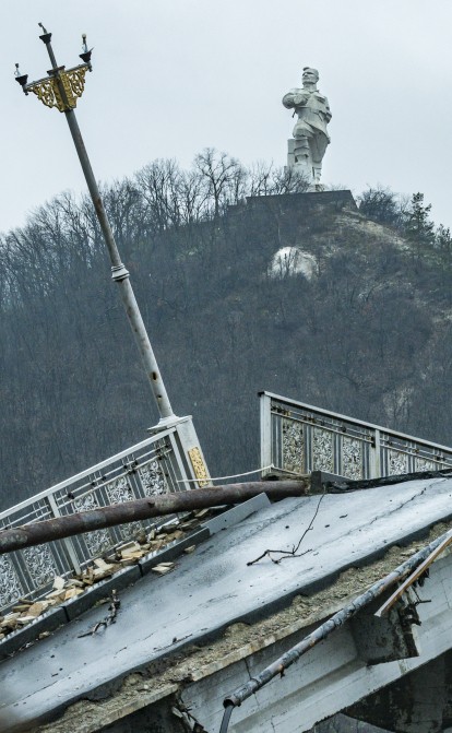 Памятник Артему над разрушенным мостом во время боев между российской и украинской армиями за контроль над городом Святогорск Донецкой области /Getty Images