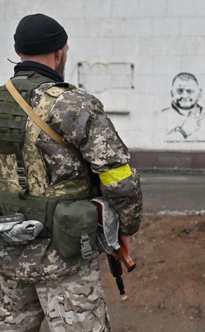 Двоє українських військових дивляться на графіті із генералом Валерієм Залужним на фасаді головного терміналу Херсонського аеропорту через місяць після звільнення ЗСУ /Getty Images