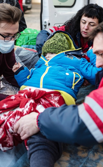 Медики эвакуируют ребенка больного раком в машину скорой помощи, которая доставит его в Польшу, 19 марта 2022. /Getty Images