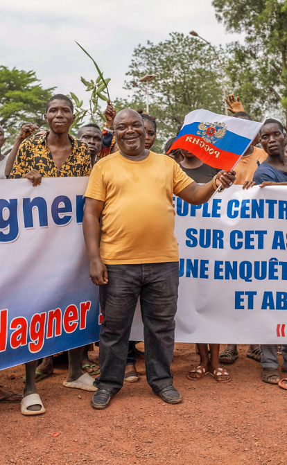 Демонстранти тримають транспаранти та прапор РФ під час маршу на підтримку присутності Росії та Китаю в Центральноафриканській Республіці, 22 березня 2023 року. /Getty Images