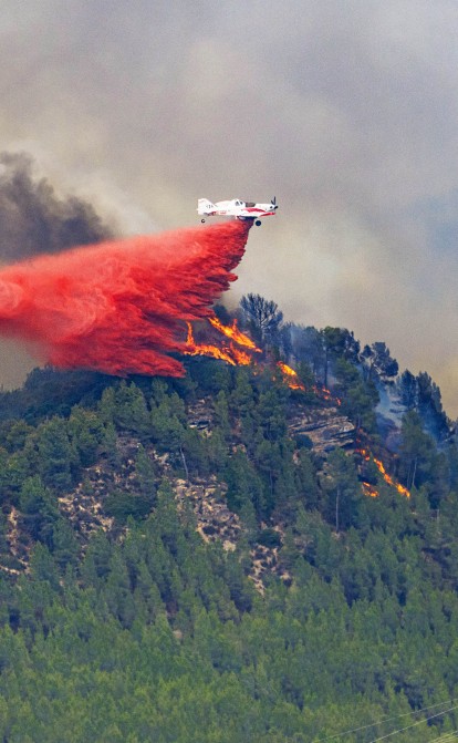 Барселона, 17 июля. Самолет тушит пожар, за день охвативший не менее 95 га территории Каталонии. Для борьбы с огнем была задействована 81 пожарная бригада, 13 из которых воздушные. /Getty Images