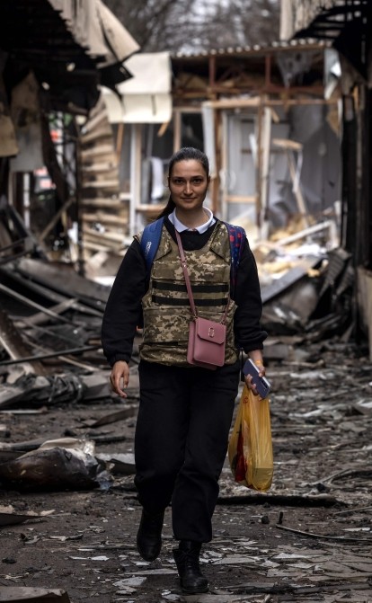 Жінка в бронежилеті йде по зруйнованому відкритому ринку в Харкові 2 квітня 2022 року