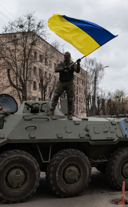 Украинский солдат размахивает государственным флагом, стоя на БТР 8 апреля 2022 в Гостомеле. После более чем пяти недель войны Россия отказалась от цели окружить украинскую столицу /Getty Images