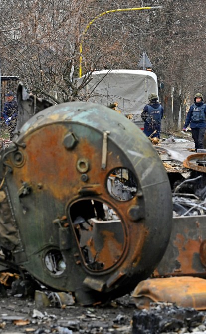 Саперы проводят разминирование среди уничтоженной бронетехники на улице в городе Буча на окраине Киева 5 апреля 2022 года. Фото GENYA SAVILOV/AFP via Getty Images /Getty Images