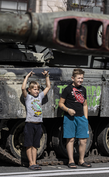 Украинские дети позируют для фото с российским танком, захваченным украинскими войсками, на Крещатике во время 31-го Дня Независимости Украины в Киеве, 24 августа 2022 года. /Getty Images
