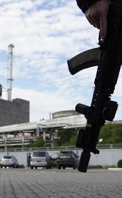 На фото від 11 вересня 2022 року озброєний чоловік стоїть перед Запорізькою атомною електростанцією в Енергодарі під час російської агресії в Україні /Getty Images