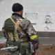 Двоє українських військових дивляться на графіті із генералом Валерієм Залужним на фасаді головного терміналу Херсонського аеропорту через місяць після звільнення ЗСУ /Getty Images