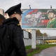 Военный курсант стоит перед билбордом, пропагандирующим контрактную армейскую службу в Санкт-Петербурге, 5 октября 2022 г. /Getty Images