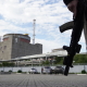 На фото від 11 вересня 2022 року озброєний чоловік стоїть перед Запорізькою атомною електростанцією в Енергодарі під час російської агресії в Україні /Getty Images